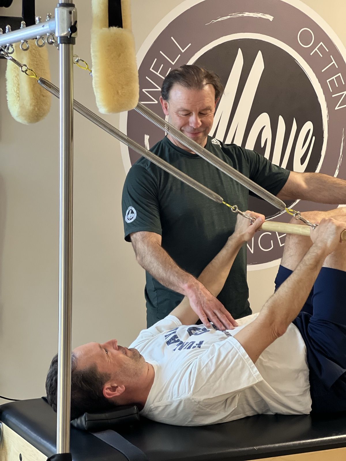 Movement Med coach guiding a client through a Pilates tower session in the Streeterville studio