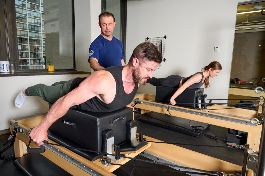 Shane coaching two clients through reformer Pilates in the Movement Med studio